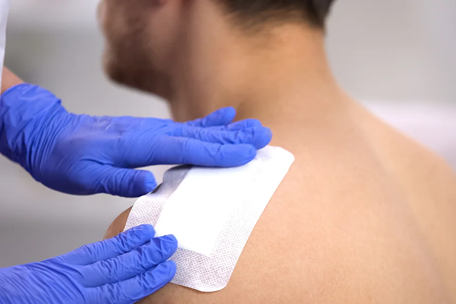 Applying medical bandage to shoulder