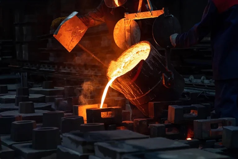 Metal foundry pouring metal into mold