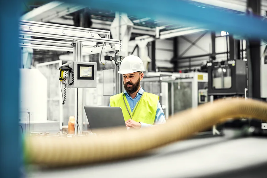 Worker with laptop in production environment