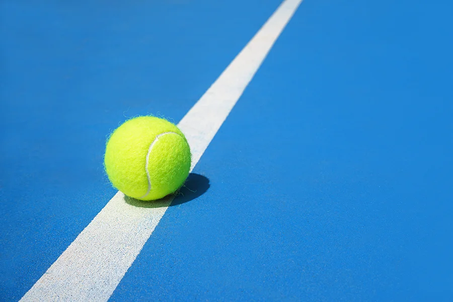 Tennis ball on blue court with white line