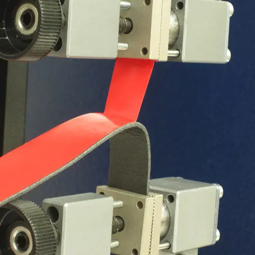 Close up image of t-peel test sample and grips