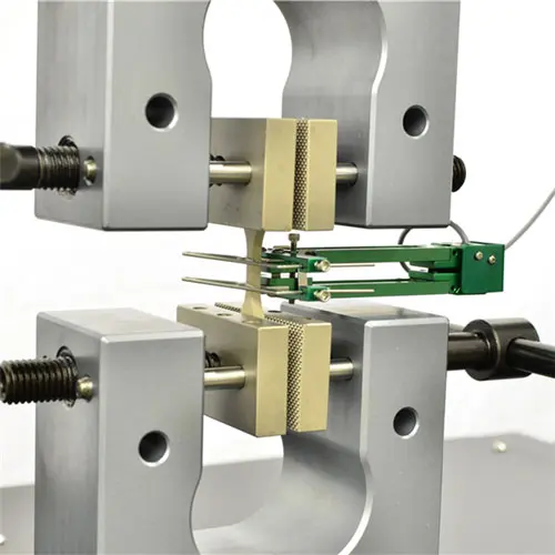 Close up image of manual vise grips holding plastic sample with extensometer attached