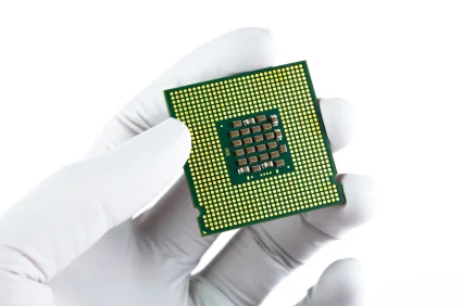 A gloved hand holding a computer processor chip